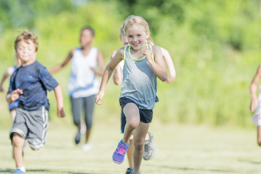 Kinder beim Laufen auf der Wiese – Bewegte Kids Sport- und Abenteuerwochen